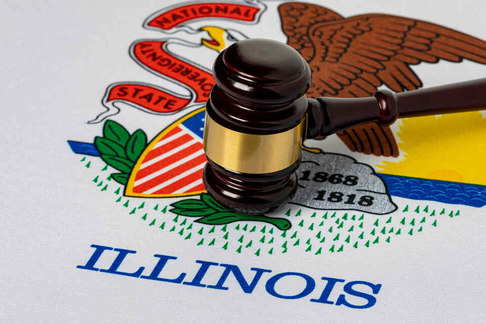 A wooden gavel over Illinois state flag