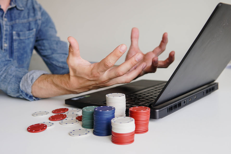 Angry man sitting in front of laptop after losing at sweepstakes casino