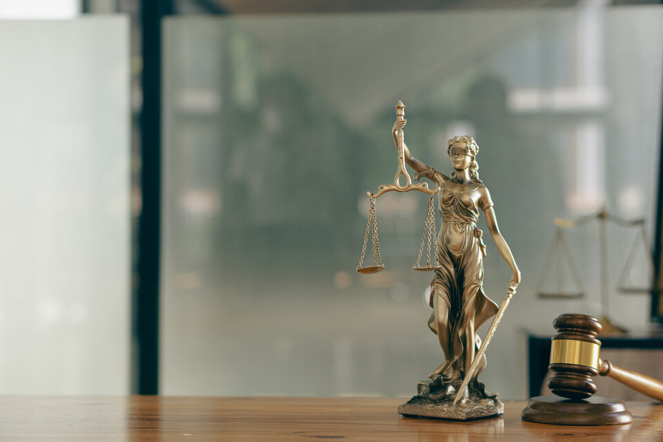 A statuette of blind justice with a gavel next to it