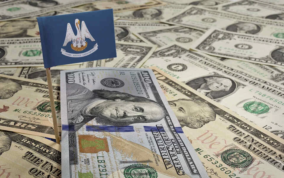 Flag of Louisiana sticking in a variety of american banknotes.